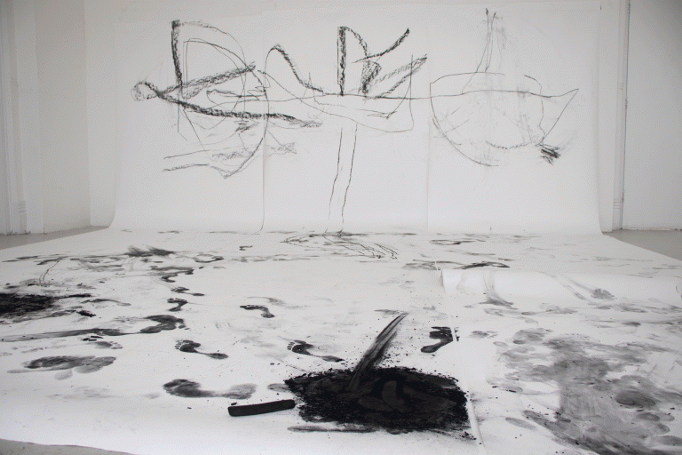MA Fine Art by Lauren Doss Showing an abstract charcoal drawing on large scale paper, that traces choreographic movement.
