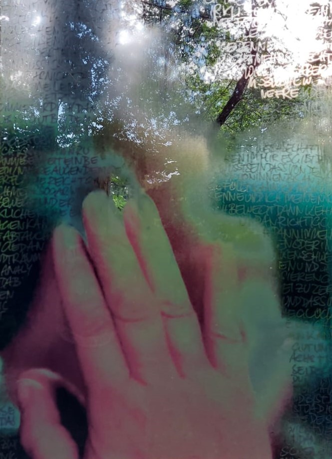 A photo print with text on acrylic showing a person in the mirror partly covered by the hand in front of the mirror.