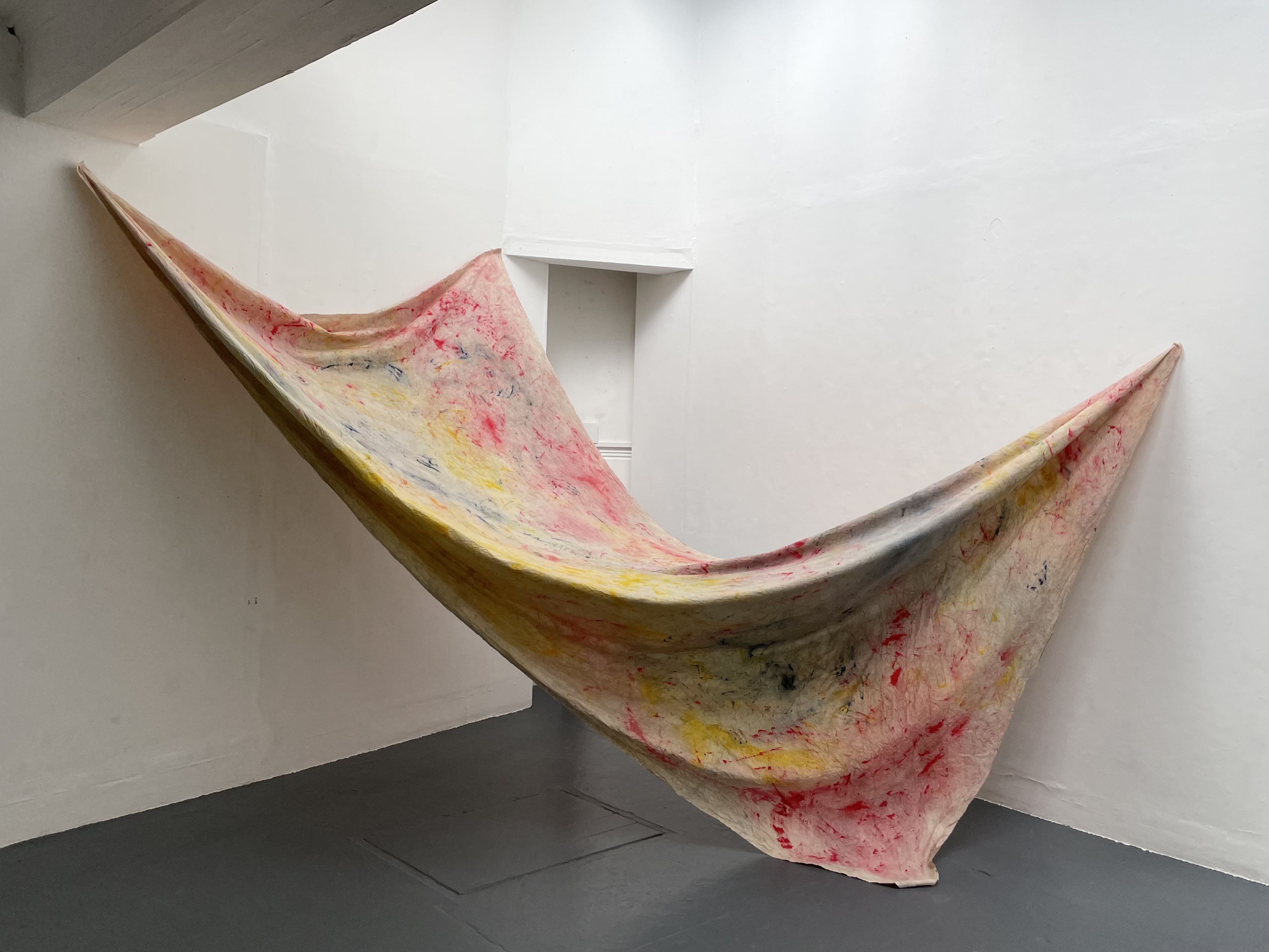 MA Fine Art work by Lauren Richeda showing a large, colourful sheet of fabric hung sculpturally.